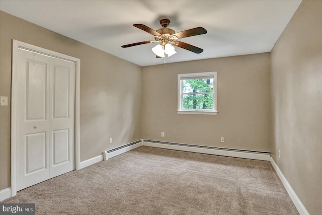 spare room featuring carpet floors, ceiling fan, baseboards, and a baseboard radiator