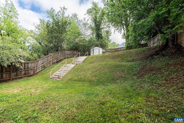 view of yard featuring a storage unit, an outbuilding, and stairway