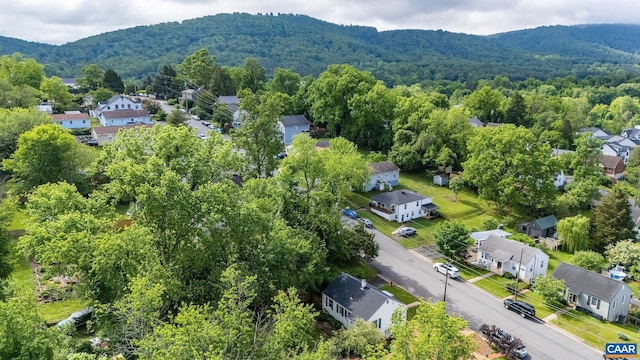 aerial perspective of suburban area with a mountainous background and a forest