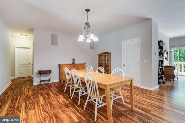 dining space with wood finished floors, baseboards, and a chandelier
