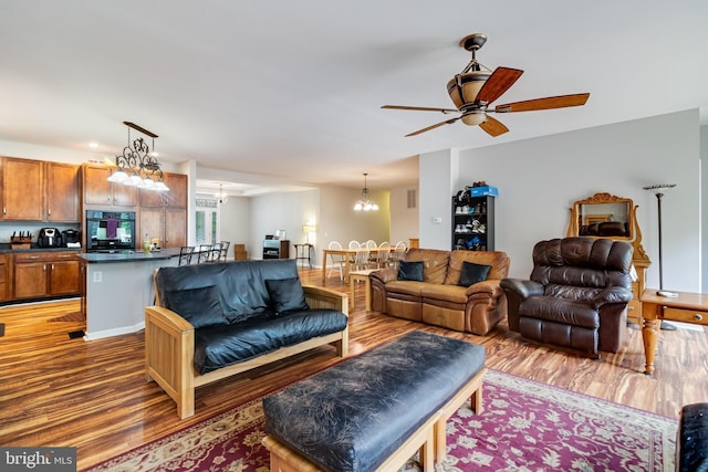 living room with wood finished floors, a chandelier, and ceiling fan