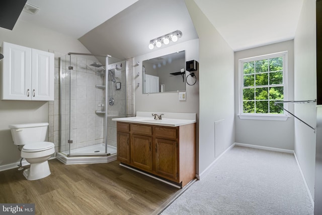 full bathroom with a shower stall, toilet, vanity, baseboards, and wood finished floors