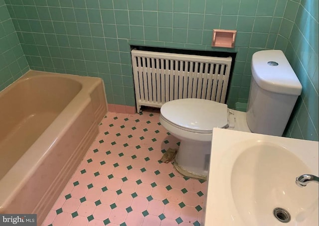 2236 Moore St, Philadelphia, PA 19145 - full bathroom featuring radiator heating unit, tile walls, tile patterned floors, toilet, and a bath