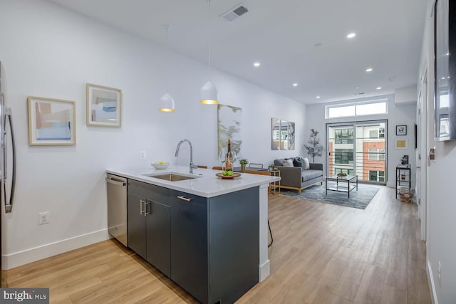 2310 4th St NE Unit 22, Washington, DC 20002 - kitchen with a sink, a peninsula, stainless steel appliances, light wood-style flooring, and light countertops