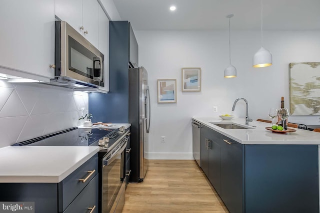 2310 4th St NE Unit 22, Washington, DC 20002 - kitchen with stainless steel appliances, a sink, a peninsula, light wood-style floors, and backsplash