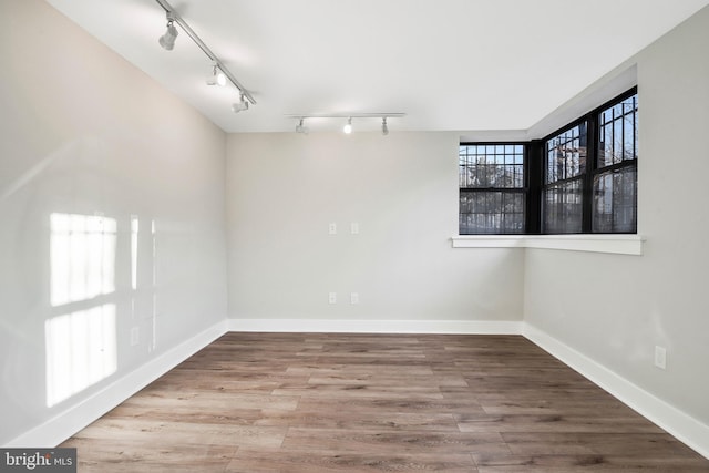 212 Oakwood St SE Unit B5, Washington, DC 20032 - empty room featuring rail lighting, baseboards, and wood finished floors