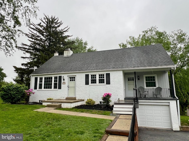 view of front of property featuring a chimney, an attached garage, a front lawn, a shingled roof, and driveway