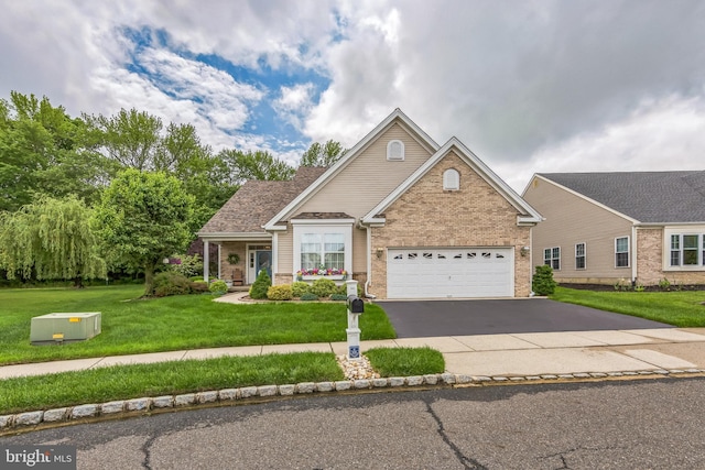 traditional-style house featuring brick siding, driveway, a front yard, and an attached garage