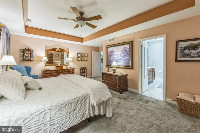 bedroom featuring carpet floors, baseboards, a tray ceiling, and a ceiling fan