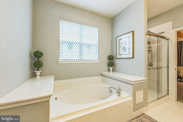 full bath featuring a stall shower, a garden tub, and tile patterned flooring