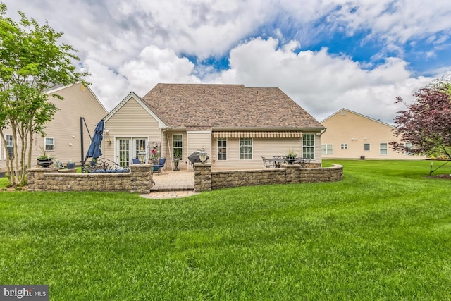 back of property featuring a patio, a lawn, a fire pit, and roof with shingles
