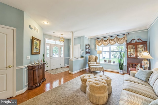 living room with hardwood / wood-style flooring, decorative columns, ornamental molding, baseboards, and recessed lighting