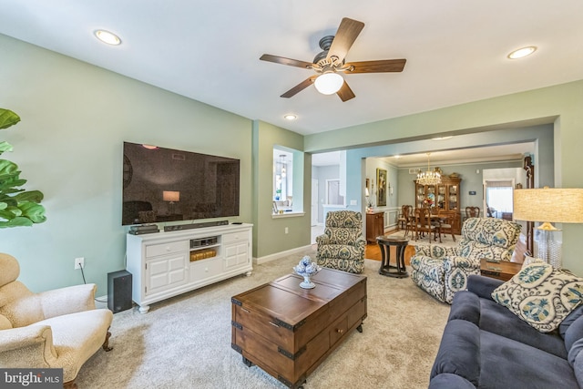 living area featuring ceiling fan, light colored carpet, a chandelier, and recessed lighting