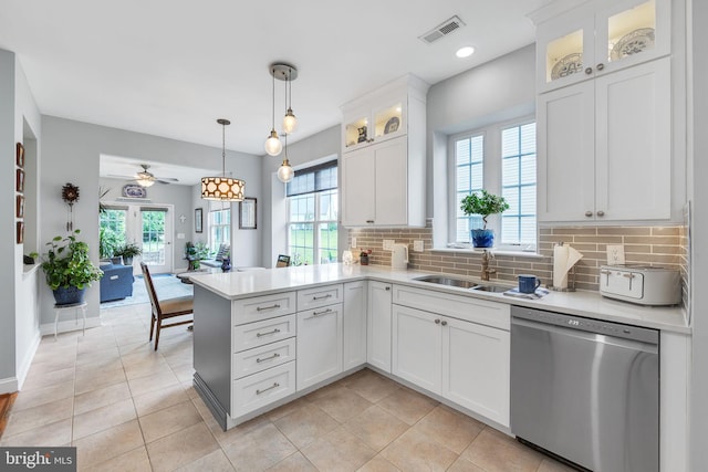 kitchen featuring stainless steel dishwasher, healthy amount of natural light, light countertops, decorative backsplash, and recessed lighting