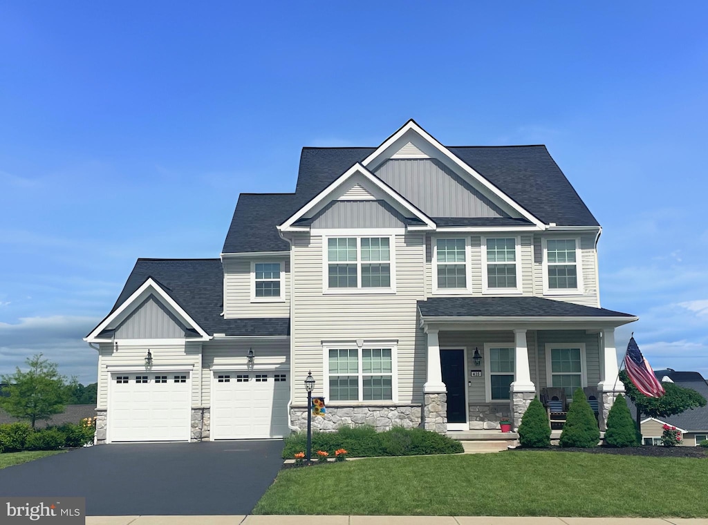 435 Hollyhock Dr, Manchester, PA 17345 - craftsman inspired home featuring board and batten siding, driveway, covered porch, a front lawn, and stone siding