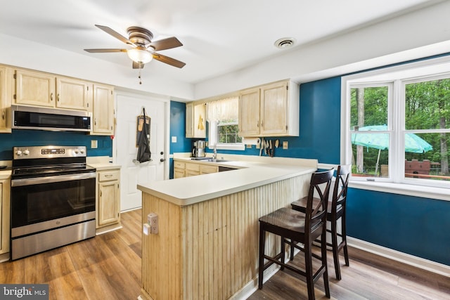 11500 Acton Ln, Waldorf, MD 20601 - kitchen featuring stainless steel appliances, light brown cabinets, wood finished floors, and light countertops