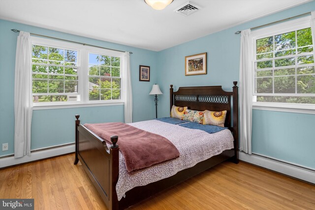 10 Hickory Dr, Doylestown, PA 18901 - bedroom featuring multiple windows, wood finished floors, baseboard heating, and a baseboard radiator