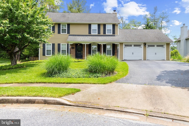 8 Pheasant Run Ct, Lutherville Timonium, MD 21093 - view of front of house with asphalt driveway, a garage, a chimney, a front yard, and a porch