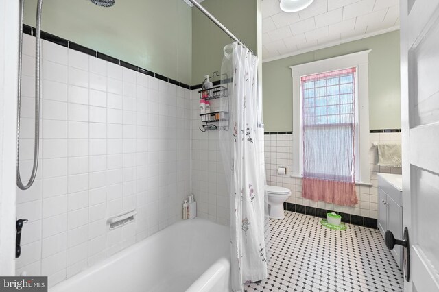 714 W St, Laurel, DE 19956 - bathroom with tile walls, shower / bath combination with curtain, vanity, tile patterned flooring, and toilet