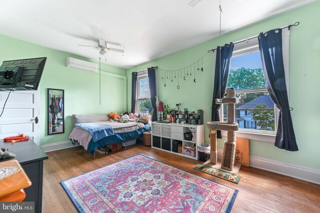 714 W St, Laurel, DE 19956 - bedroom with a wall unit AC, wood finished floors, baseboards, and ceiling fan
