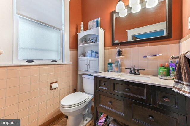 714 W St, Laurel, DE 19956 - bathroom featuring tile walls, toilet, vanity, and wainscoting