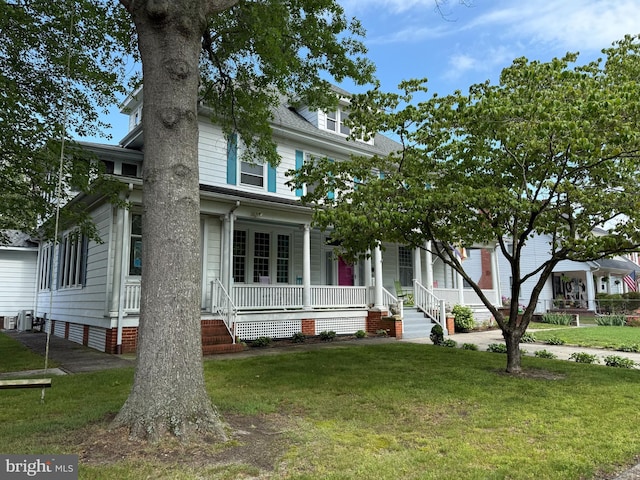 714 W St, Laurel, DE 19956 - american foursquare style home featuring a porch, a front lawn, and central AC
