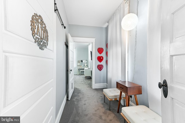 714 W St, Laurel, DE 19956 - corridor featuring dark colored carpet, a barn door, and baseboards