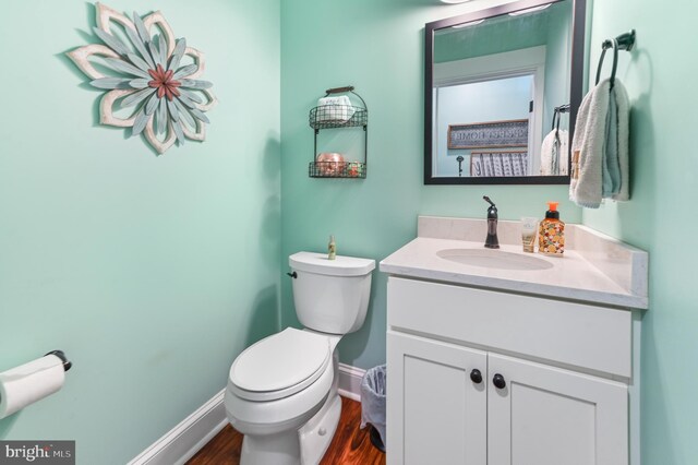 714 W St, Laurel, DE 19956 - bathroom with toilet, vanity, baseboards, and wood finished floors