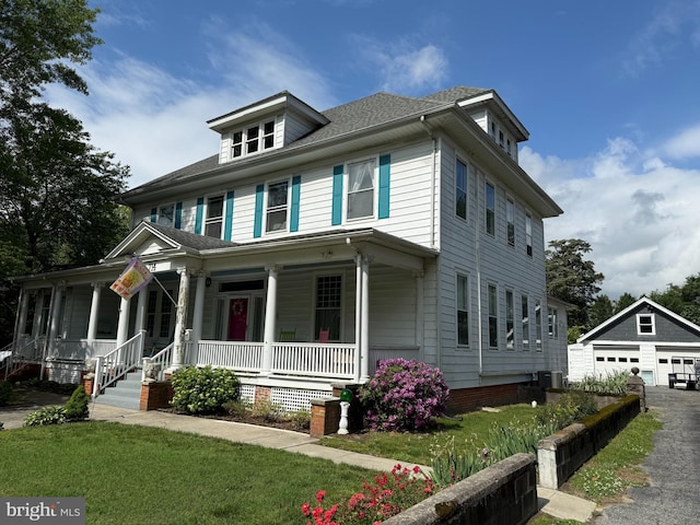 714 W St, Laurel, DE 19956 - american foursquare style home with a porch, an outbuilding, a garage, cooling unit, and a front lawn