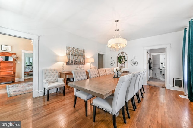 714 W St, Laurel, DE 19956 - dining area featuring a chandelier, wood-type flooring, and baseboards