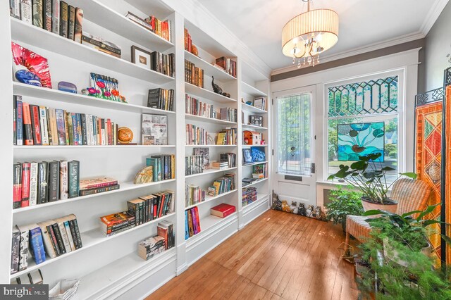 714 W St, Laurel, DE 19956 - living area with ornamental molding, hardwood / wood-style floors, a chandelier, and bookshelves