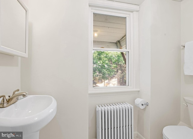 46 Murray Ave, Annapolis, MD 21401 - bathroom with radiator, toilet, a sink, and baseboards