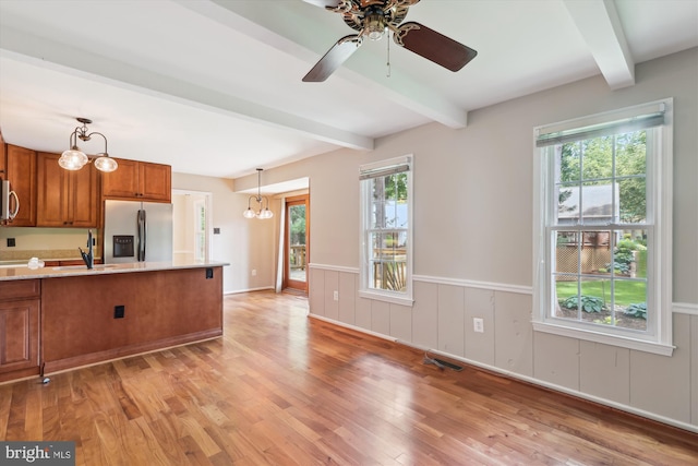 10007 Marshall Pond Rd, Burke, VA 22015 - kitchen featuring appliances with stainless steel finishes, brown cabinetry, beam ceiling, light wood-style flooring, and decorative light fixtures