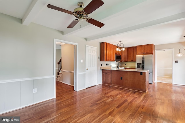10007 Marshall Pond Rd, Burke, VA 22015 - kitchen with appliances with stainless steel finishes, beamed ceiling, brown cabinets, a peninsula, and a sink