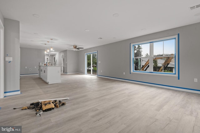 1500A Embassy, Harrisburg, PA 17109 - unfurnished living room with light wood finished floors, baseboards, ceiling fan, and baseboard heating
