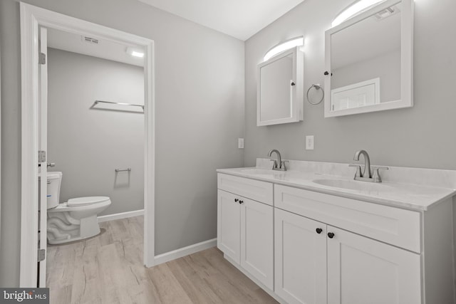 1500A Embassy, Harrisburg, PA 17109 - bathroom featuring wood finished floors, toilet, double vanity, and baseboards