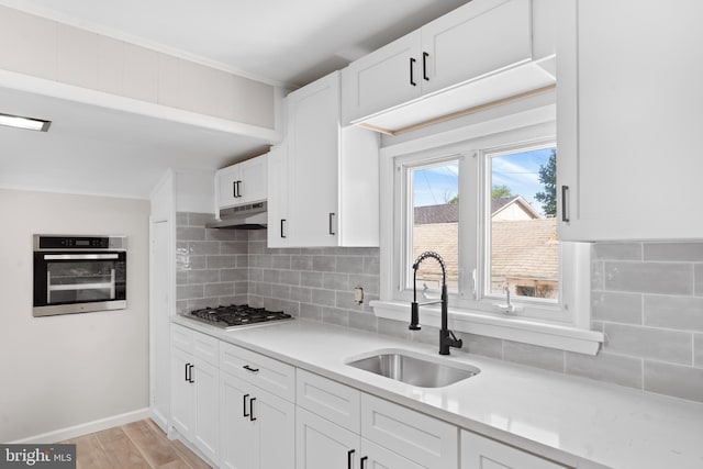 341 Ives Ave, Penns Grove, NJ 08069 - kitchen featuring stainless steel appliances, a sink, under cabinet range hood, tasteful backsplash, and crown molding