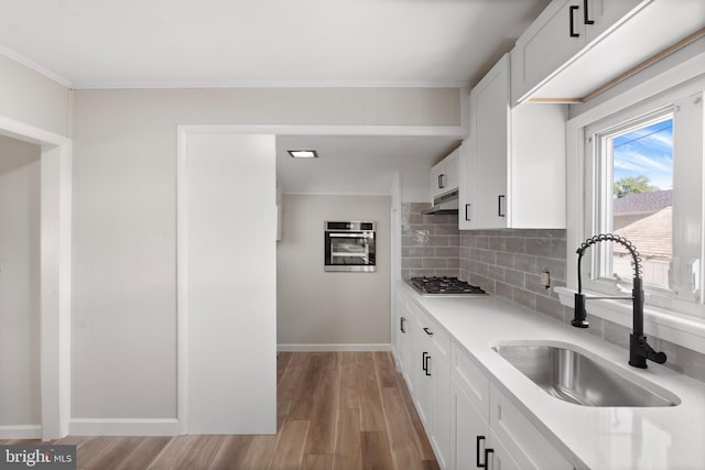 341 Ives Ave, Penns Grove, NJ 08069 - kitchen featuring a sink, stainless steel appliances, light countertops, under cabinet range hood, and light wood-style flooring