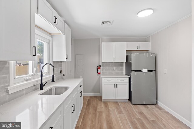 341 Ives Ave, Penns Grove, NJ 08069 - kitchen with freestanding refrigerator, a sink, light wood-style floors, white cabinetry, and tasteful backsplash