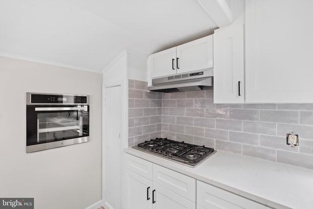 341 Ives Ave, Penns Grove, NJ 08069 - kitchen with appliances with stainless steel finishes, under cabinet range hood, ornamental molding, white cabinetry, and light stone counters