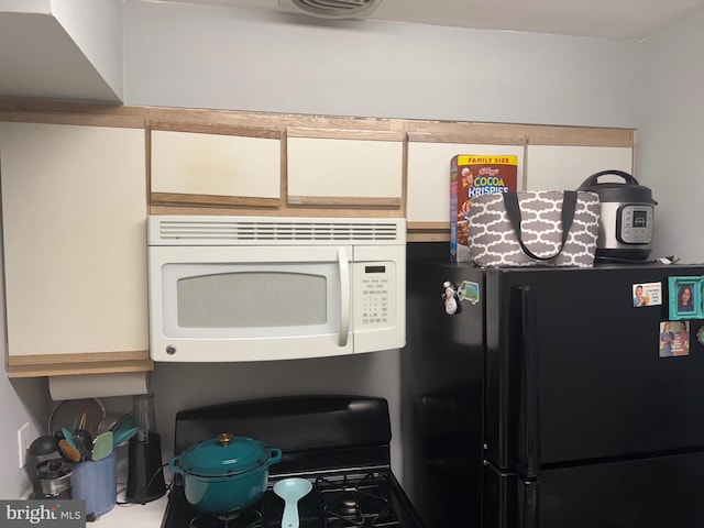 441 Tomlinson Rd Unit E18, Philadelphia, PA 19116 - detailed view of white microwave, freestanding refrigerator, and gas range