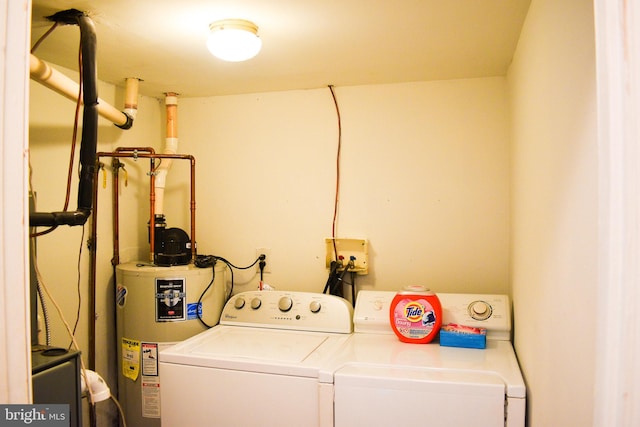 clothes washing area featuring washing machine and clothes dryer and water heater
