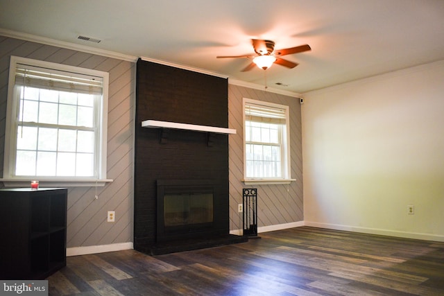 unfurnished living room featuring baseboards, dark wood-style floors, ceiling fan, ornamental molding, and a fireplace