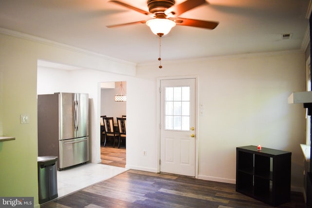 entrance foyer with ornamental molding, ceiling fan, wood finished floors, and baseboards