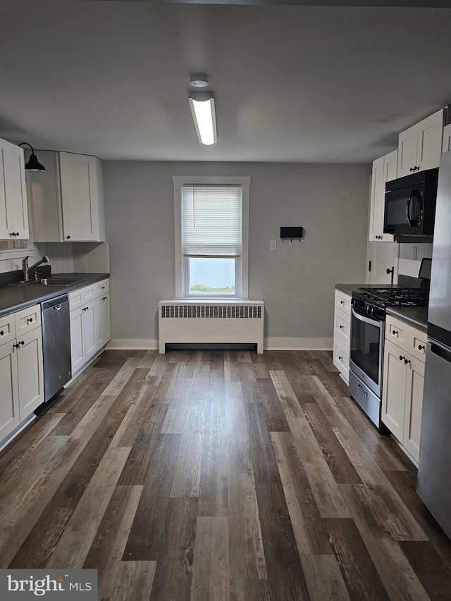 10992 Roxbury Rd, Orrstown, PA 17244 - kitchen with radiator, appliances with stainless steel finishes, dark countertops, white cabinets, and decorative backsplash