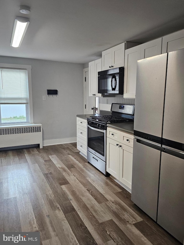 10992 Roxbury Rd, Orrstown, PA 17244 - kitchen featuring stainless steel appliances, radiator, dark countertops, and wood finished floors