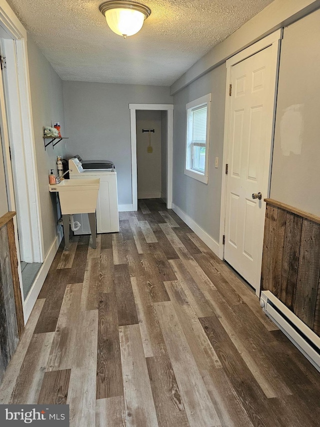 10992 Roxbury Rd, Orrstown, PA 17244 - clothes washing area with a textured ceiling, a baseboard radiator, wood finished floors, and baseboards