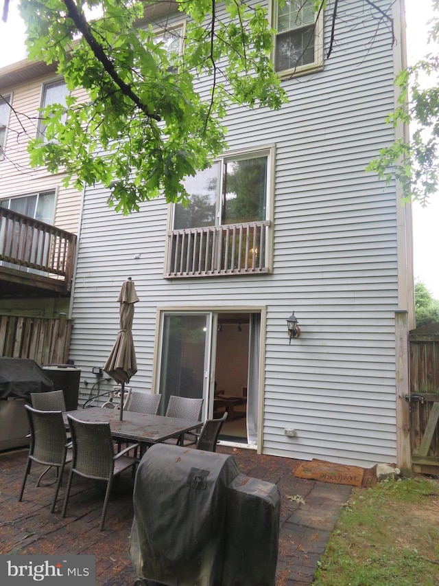 rear view of property with outdoor dining space and fence