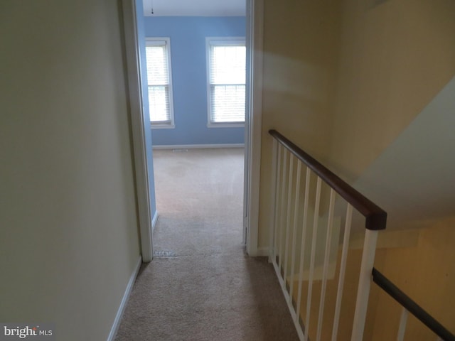corridor with carpet flooring and baseboards