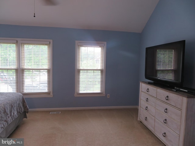 bedroom featuring baseboards, light colored carpet, multiple windows, and vaulted ceiling